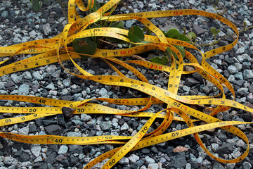 Broken yellow measuring tape on the ground