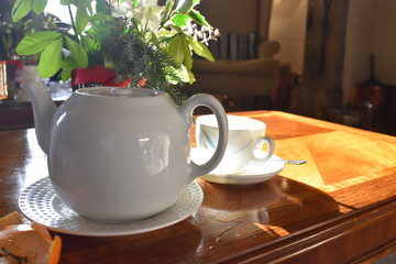 A Teapot and a cup of hot tea on wooden table, Traditional english tea