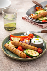 Grilled sausages with vegetables and sauce. Summer concept.