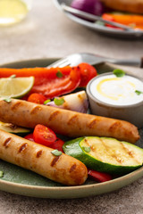Grilled sausages with vegetables and sauce. Summer concept.