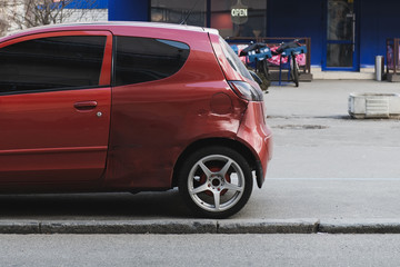 Small red car after a crash accident. Side impact. Poor quality painting. Wrong colour car's door....