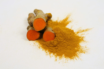 Fresh turmeric and turmeric powder, isolated on a white background, are ingredients in the diet....