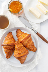 Breakfast with croissants, tea and orange jam.