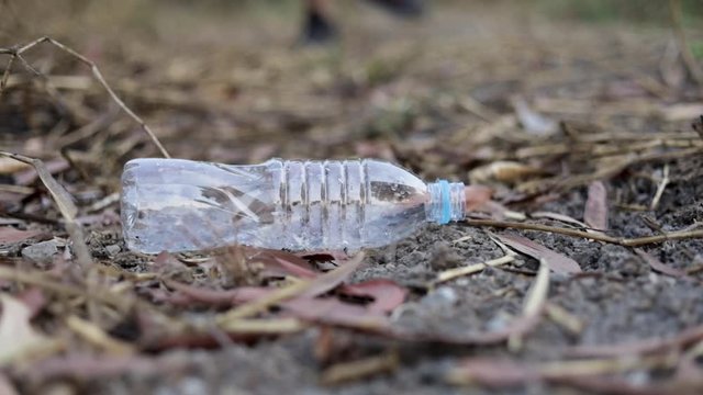 Men leg is stepping on a plastic bottle and picks up ,stop plastic, environmental concept