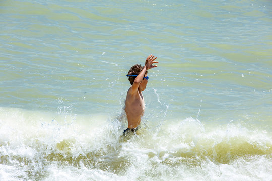 Boys playing with waves of the Black Sea, Summer and holidays in Romania