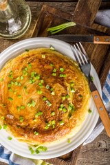 Homemade Breakfast Spaghetti Omelette with Eggs and green Onions, wooden rustic background