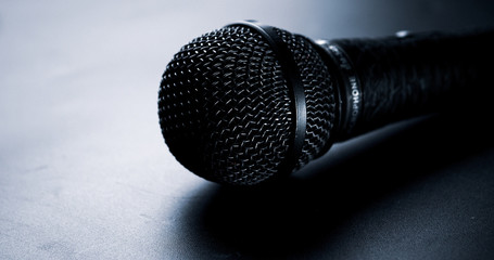 Close up of black microphone on a black background.