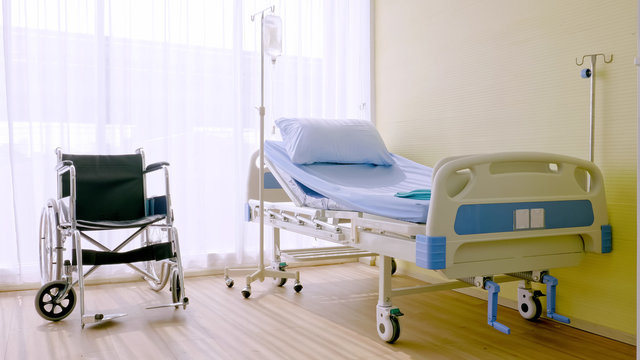 Hospital bed and wheelchair at hospital room.