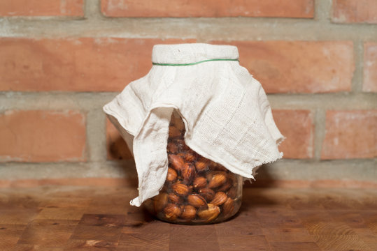 Sprouting almonds in a glass jar covered with a cheese cloth