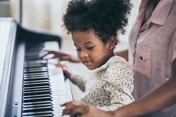American African young pianist, teacher teaching girl kid student to play piano, Art of music...