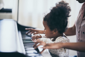 American African young pianist, teacher teaching girl kid student to play piano, Art of music...