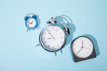 top view of alarm clocks on blue background