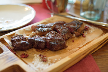 beef steak on a wooden board in a restaurant.