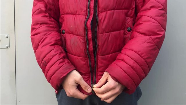 man zips up on a red jacket