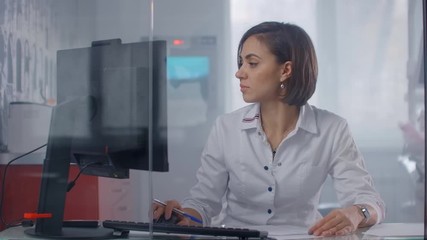Close up of female doctor sitting at the table in hospital and typing at laptop computer. Young Woman Doctor Nurse in Hospital Clinic Office - Powered by Adobe