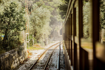 Fototapeta premium Retro wooden train traveling along railroad in mountains. Beautiful sunny summer landscape. Majorca, Spain. 