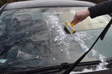 Frosty morning, ice cover window car, bad weather conditions, scraping ice from the car windows by...