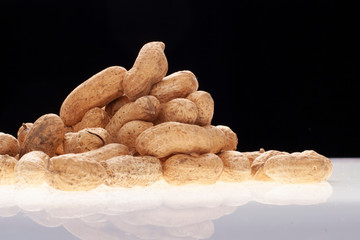 amandoim em pilha no fundo preto