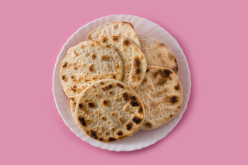 Handmade matzah for Jewish Passover on pink background. Top view