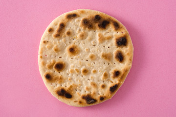 Handmade matzah for Jewish Passover on pink background. Top view