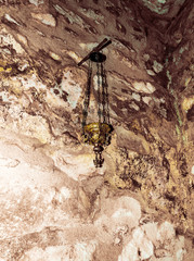 Close up of a hanging brass and class candle holder hanging in Orthodox Church in Penteli, Greece