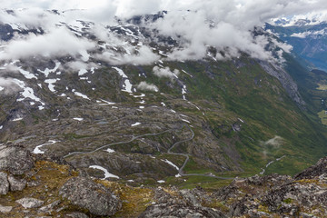Mountain serpentine road surrounded by clouds leading to Dalsnibba mountain, Norway, selective focus. View from the viewpoint.