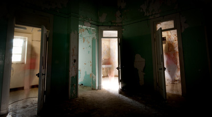 Fototapeta na wymiar Unrecognised person walking alone through the doors of an abandoned room.