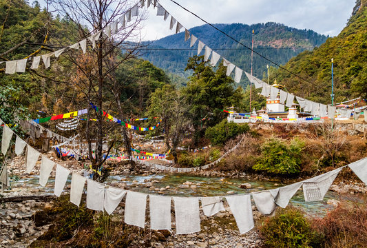 Traditional prayer multicolor Tibetan Buddhist flags Lung Ta over the river in Bhutan in the Thimphu River valley.