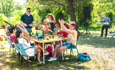 Happy friends having fun together at barbeque pic nic party - Multiracial young people at open air...