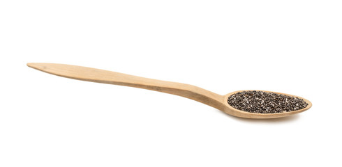 Side view at low angle of chia seeds on a wood spoon isolated on white background