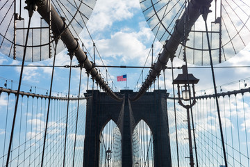 Obraz premium Łuki na moście Brooklyn Bridge z amerykańską flagą w Nowym Jorku