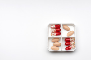 daily boxes with different tablets and capsules, top view.