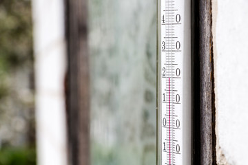 old glass thermometer for measuring outdoor temperature, showing twenty degrees centigrade, closeup