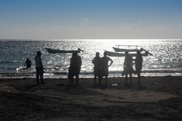 Fototapeta premium a sporty friends group on the beach about to go swimming. Silhouette people group on the beach at Tulum