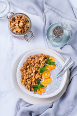 Chia pudding bowl with homemade granola and kumquats for breakfast