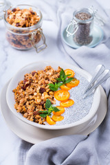 Chia pudding bowl with homemade granola and kumquats for breakfast