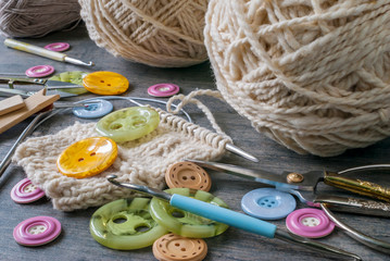 Knitting threads, knitting needles, buttons, hooks and scissors.