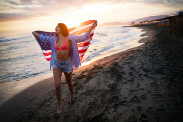 Fototapeta na wymiar Happy woman running on beach while celebrateing independence day and enjoying freedom in USA