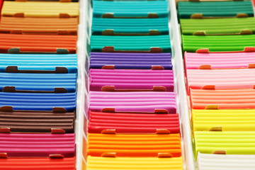 Plasticine in a box of multi-colored pieces in full screen, material for modeling.