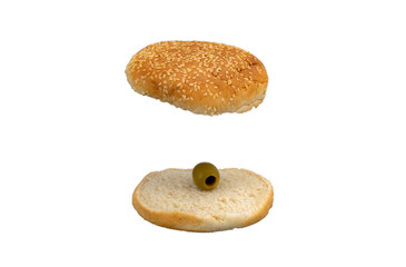Top and bottom of hamburger bun with sesame and a green olive on a white background