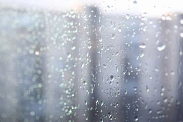 Naklejka na ściany i meble Close-up condensate on window, drops on glass. Background raindrops flow down car glass. Sad mood, rain hits window. Shower outside windows. Rainy mood in autumn. Spring on windshield
