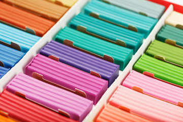 Plasticine in a box of multi-colored pieces in full screen, material for modeling.
