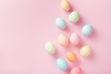 Pastel Easter eggs on pink background top view. Flat lay style.