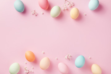 Pastel Easter eggs on pink background top view. Flat lay style.
