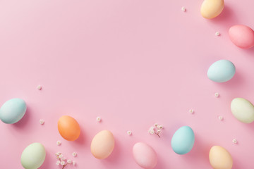 Pastel Easter eggs on pink background top view. Flat lay style.