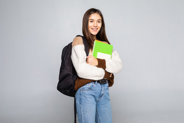 Young woman with a bag and red books on her hands over white background