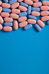 HIV/AIDS therapy pills on pink background.