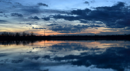 Obraz premium Beautiful evening landscape with reflection of clouds in a lake