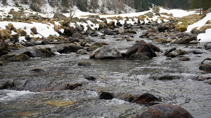spring in the mountains with melt water in a creek