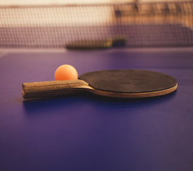 Tennis racket and ball on blue table, game concept
